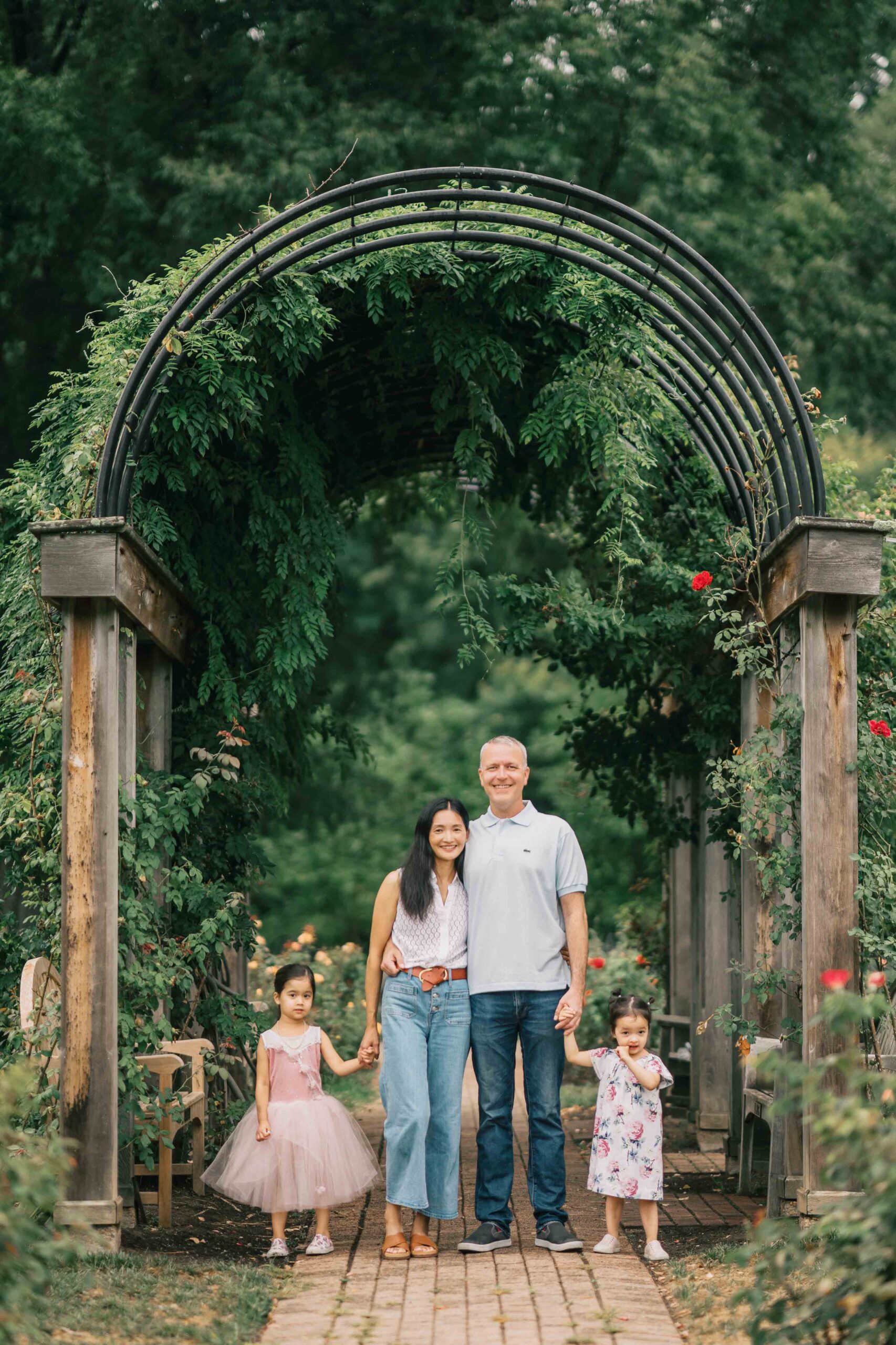 family of four at Bon Air Rose Garden for family photos in Arlington Virginia under plant arch