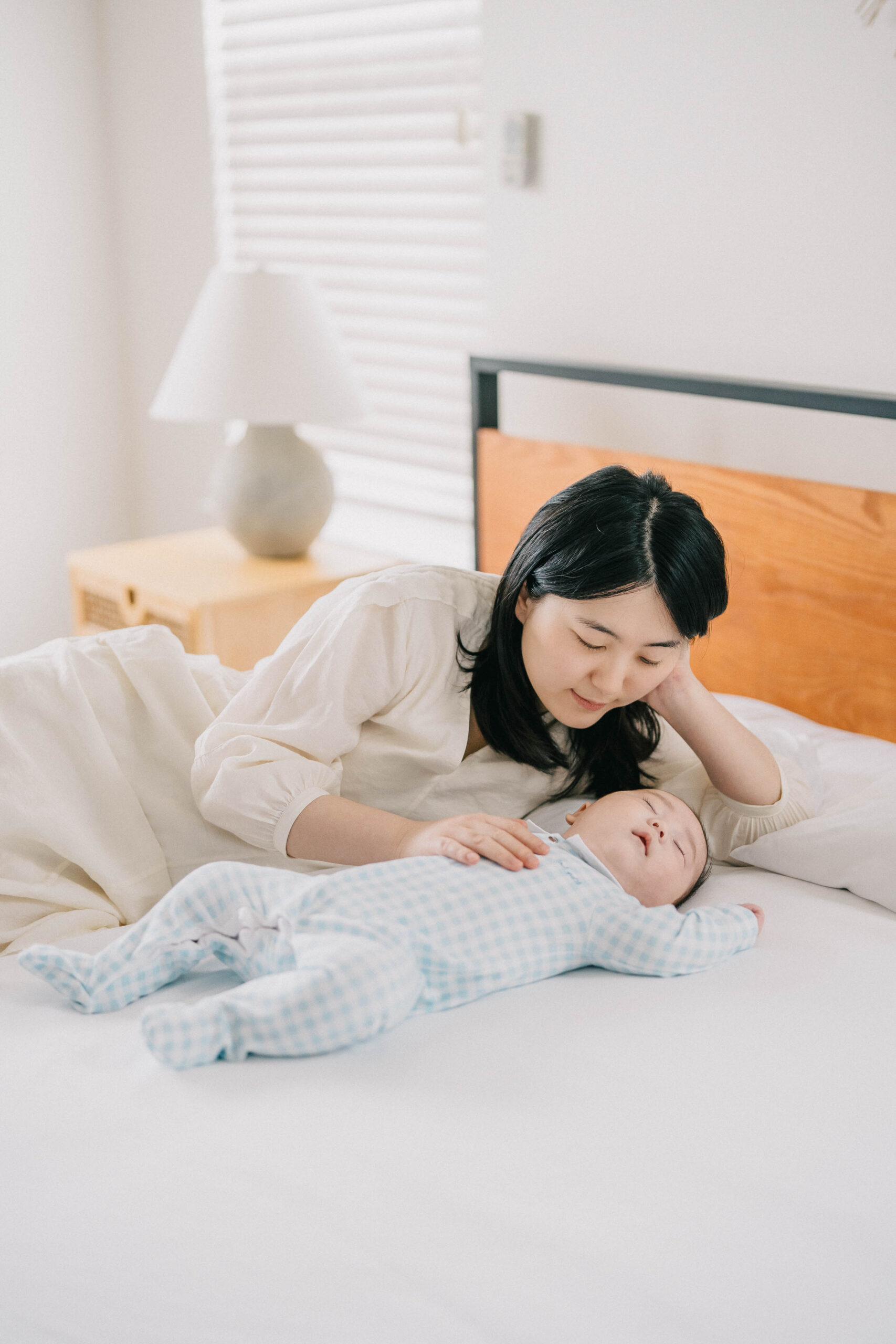 mum lying down looking at her baby with smile